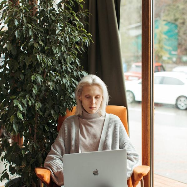 Person sitting in a comfortable chair by the window focusing on breathing.